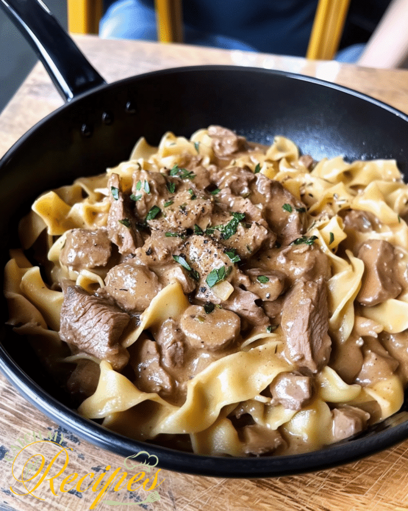 Beef Stroganoff Recipe Without Mushrooms 2 Beef stroganoff with creamy sauce and parsley over egg noodles in a black bowl.