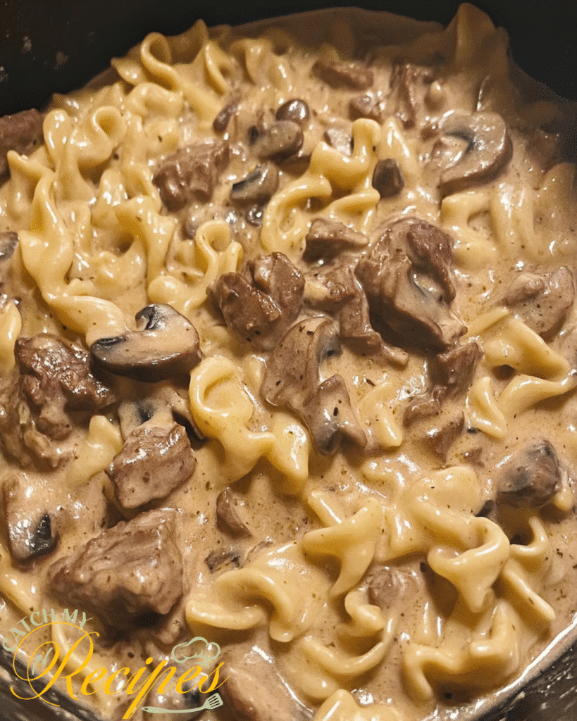 Creamy Dutch Oven Beef Stroganoff 2 Beef stroganoff with egg noodles, mushrooms, and creamy sauce in a pot.