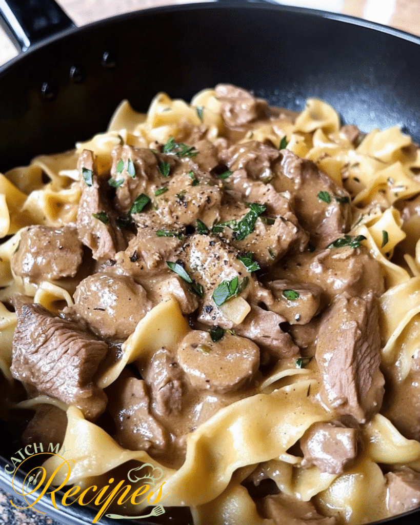 Beef Stroganoff Recipe Without Mushrooms 5 Creamy beef stroganoff with egg noodles and fresh herbs in a black skillet.