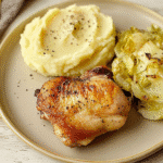 chicken thigh and cabbage recipe with mashed potatoes garnished with black pepper