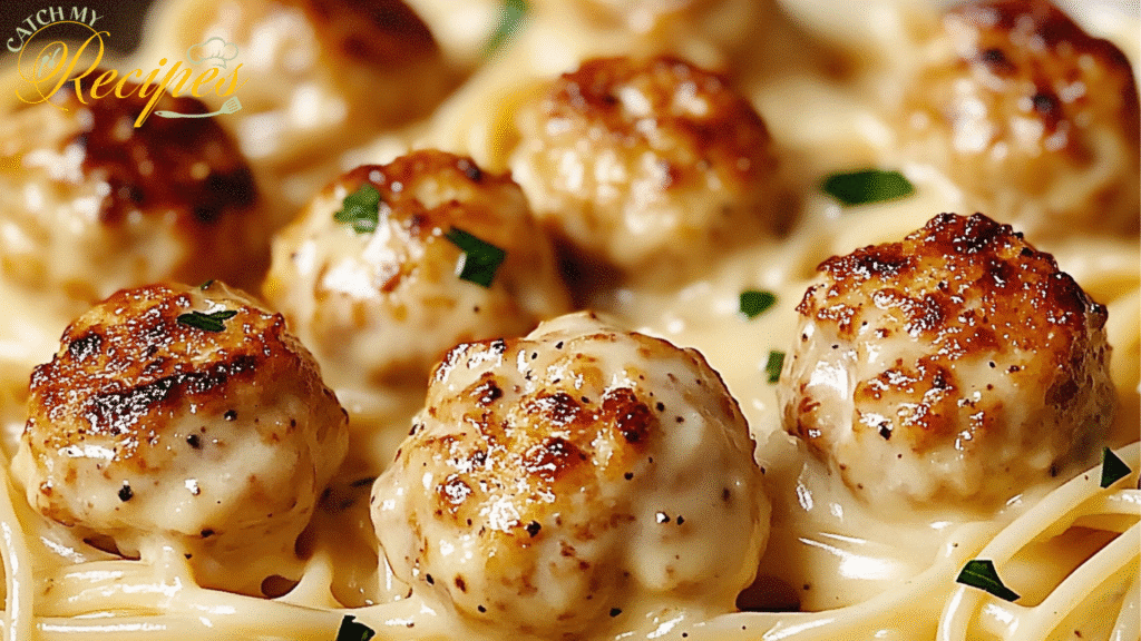 Creamy pasta dish with chicken bites and fresh parsley on a bed of spaghetti.